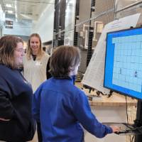 two people looking at a project on a tv